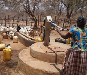 Woman collecting water at a hand pump in Kyuso, Kenya