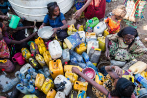 Huseyna Faraha, 20 years old, helping others in pouring water in their containers. Credit: UNICEF Ethiopia