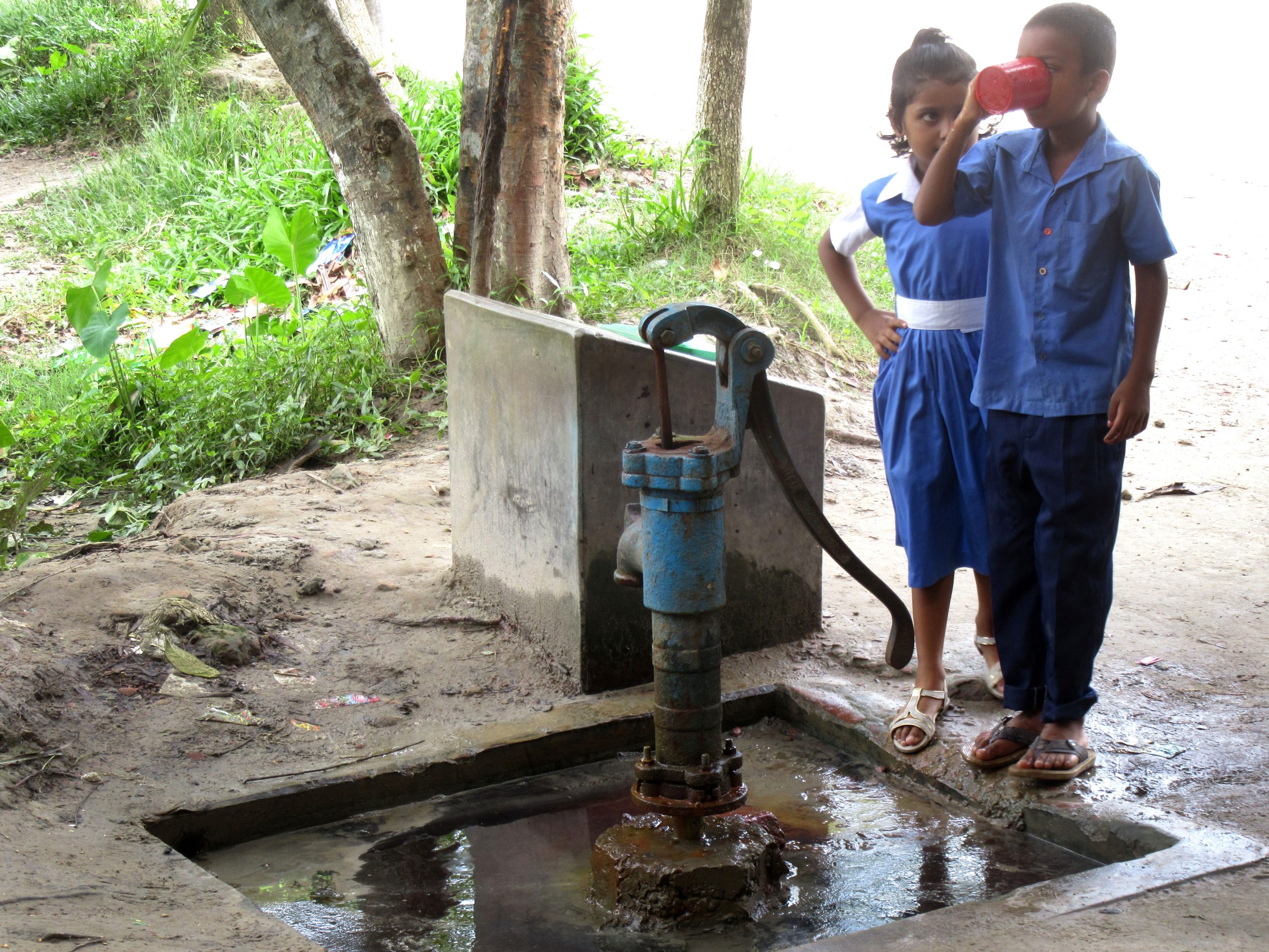 Children drinking water from a tube well in Bangladesh; Photo Credit: Rob Hope/REACH