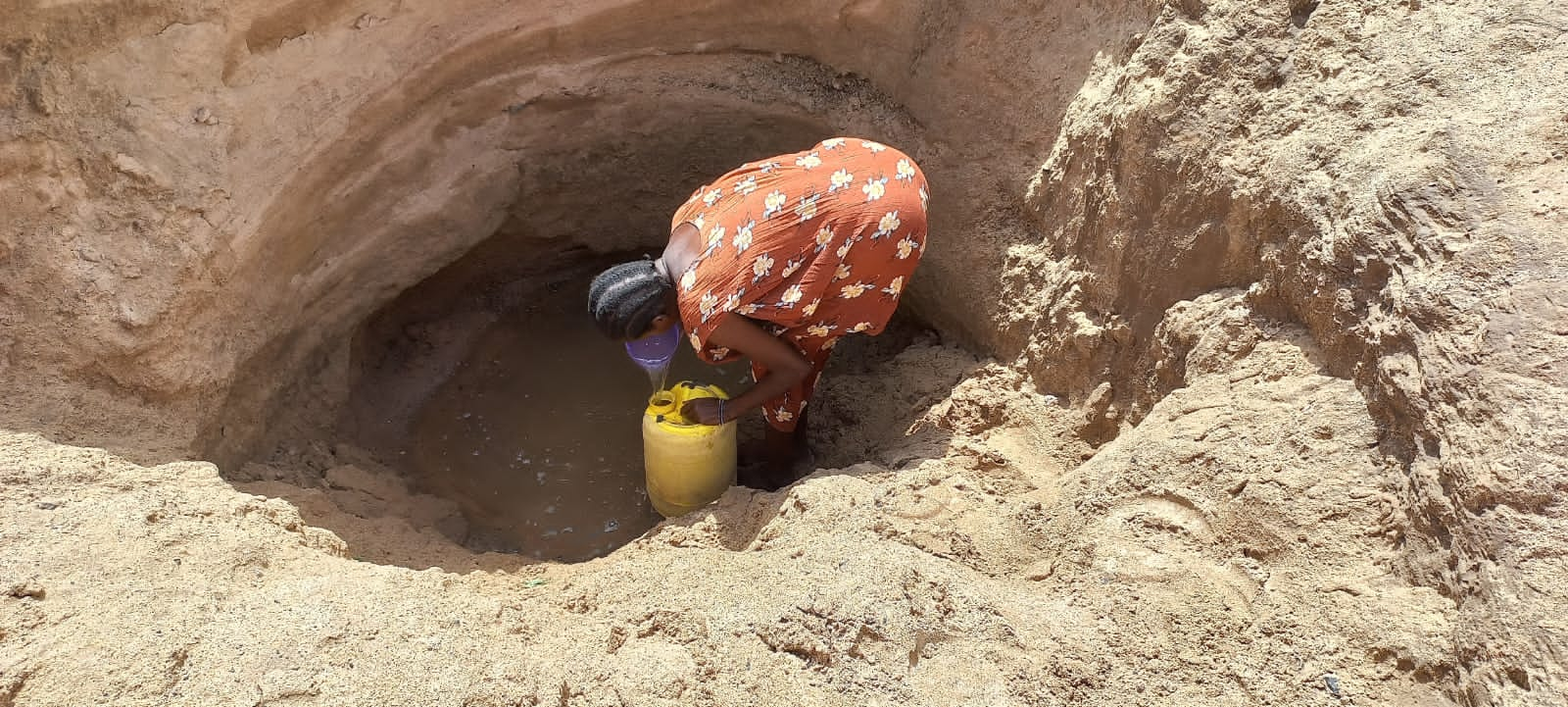 Woman fetching water in a dug-out dry Kawalase river bed. Photo taken by Mercy Mbithe